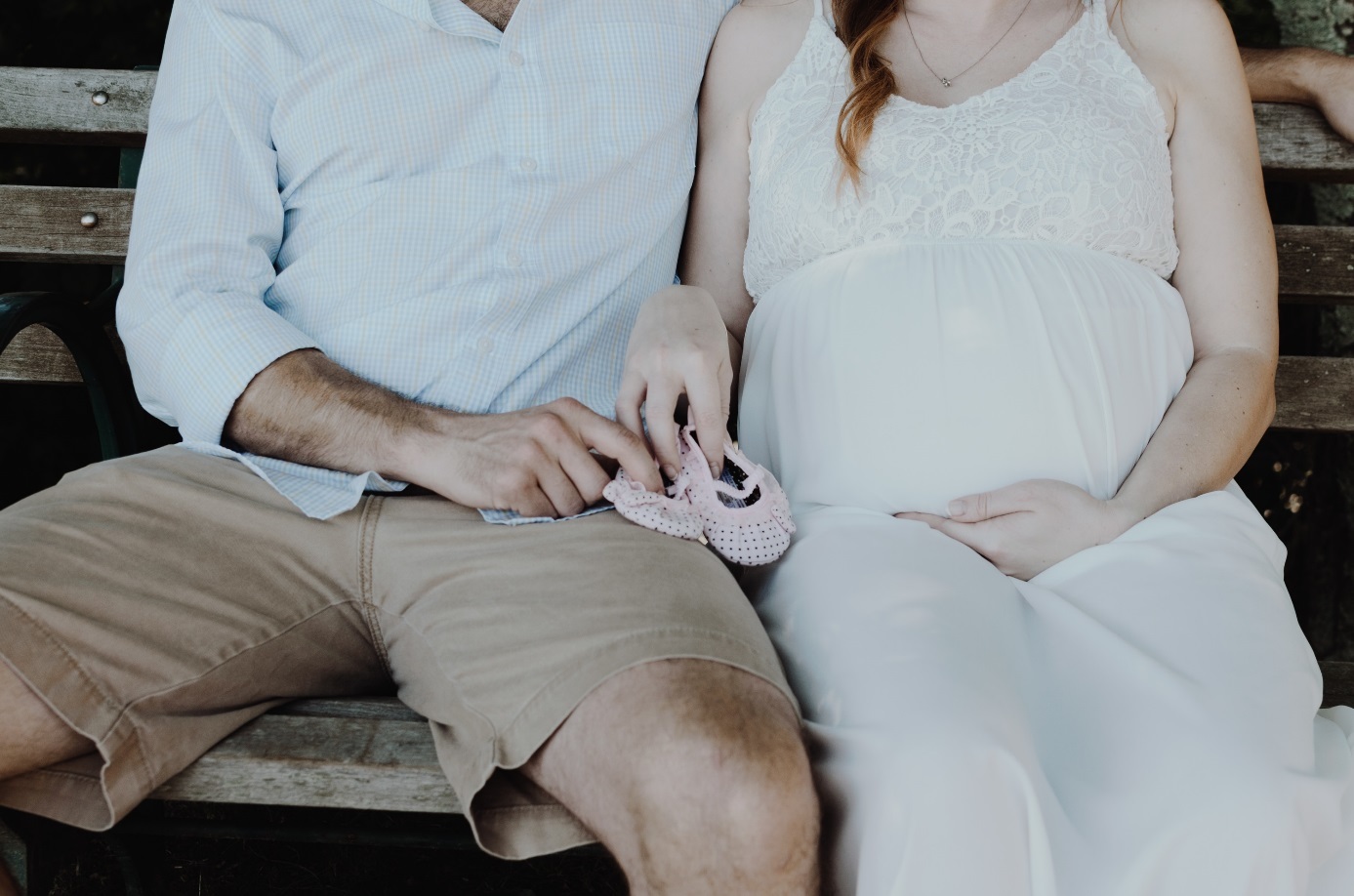 Mann und schwangere Frau sitzen auf einer Bank