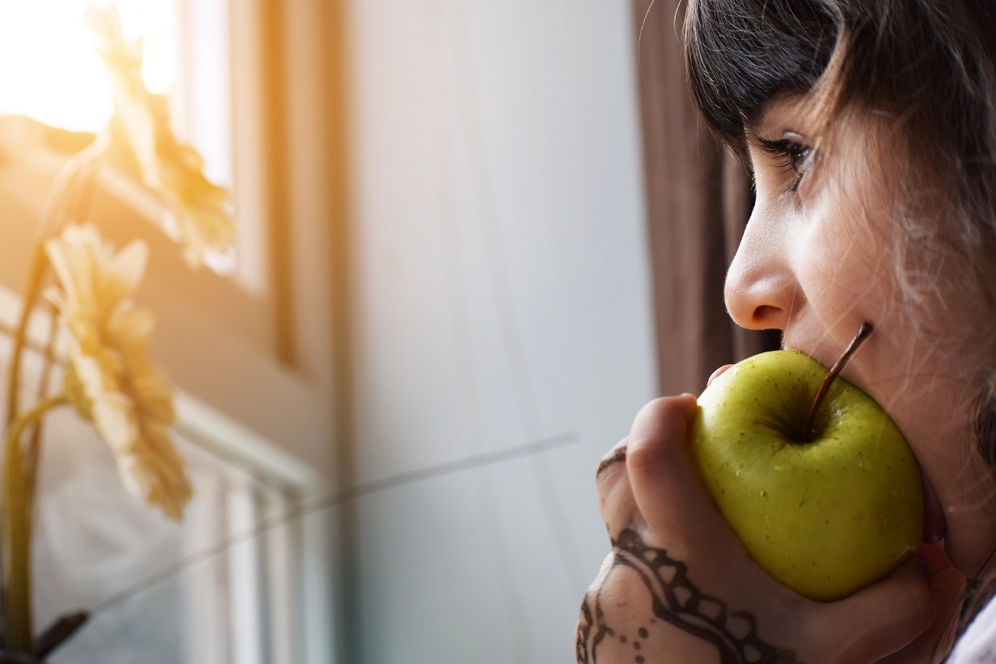 Mädchen beißt von einem Apfel ab.