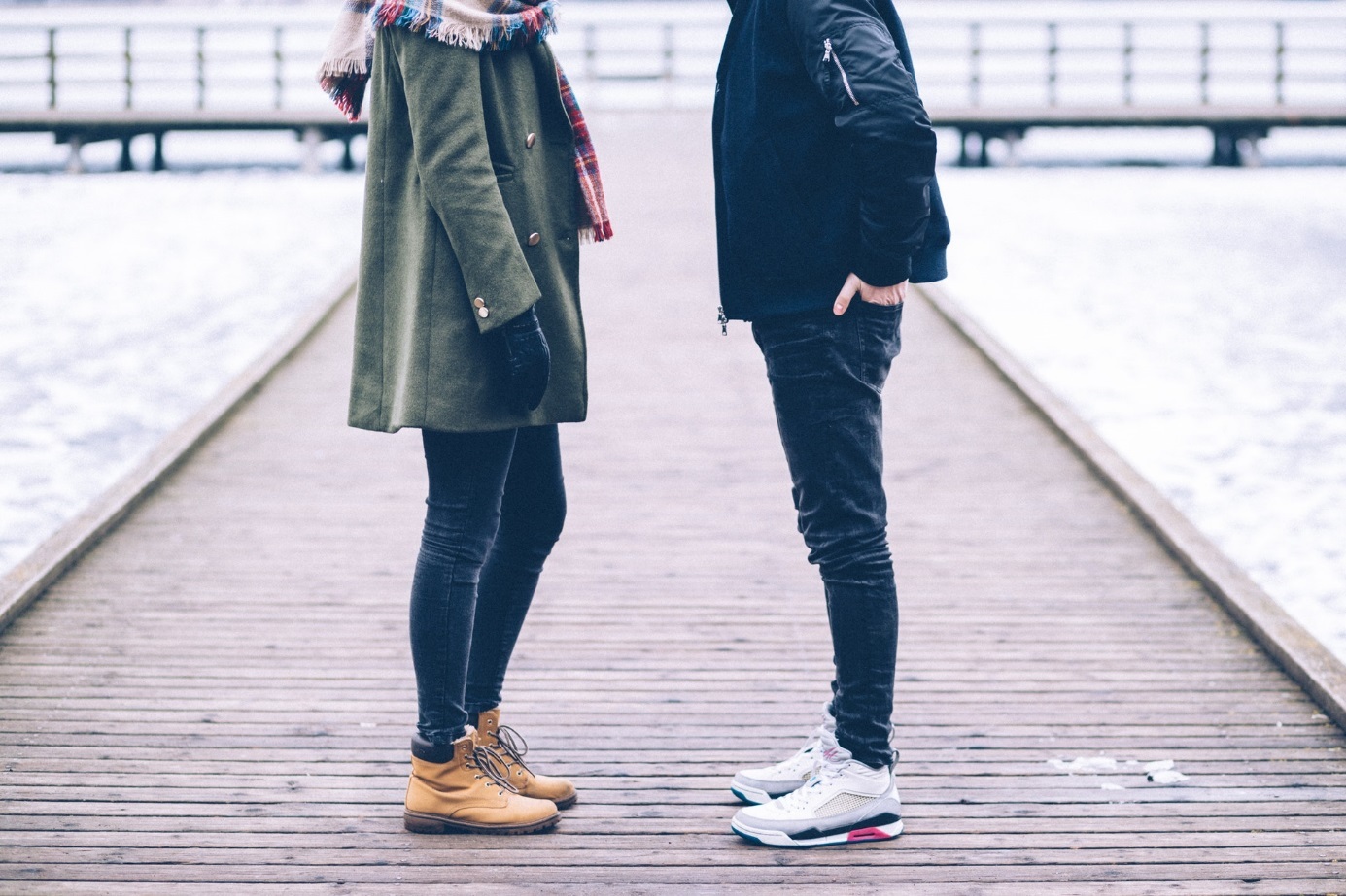 Frau und Mann auf Seebrücke in winterlicher Umgebung